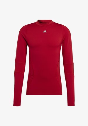Rotes Langarmshirt aus dehnbarem Stoff, mit hohem Kragen, flachen Nähten und einem kleinen silbernen Logo auf der Brust.