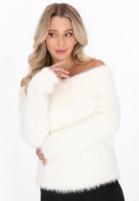 Biały sweter typu off-the-shoulder o miękkiej, puszystej strukturze; prążkowany dekolt; długie rękawy; dopasowany krój; minimalne akcenty.