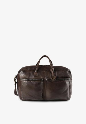 Bolso de viaje de cuero marrón con asas dobles y una correa de hombro ajustable. Cuenta con dos bolsillos frontales y un colgante decorativo de ancla.