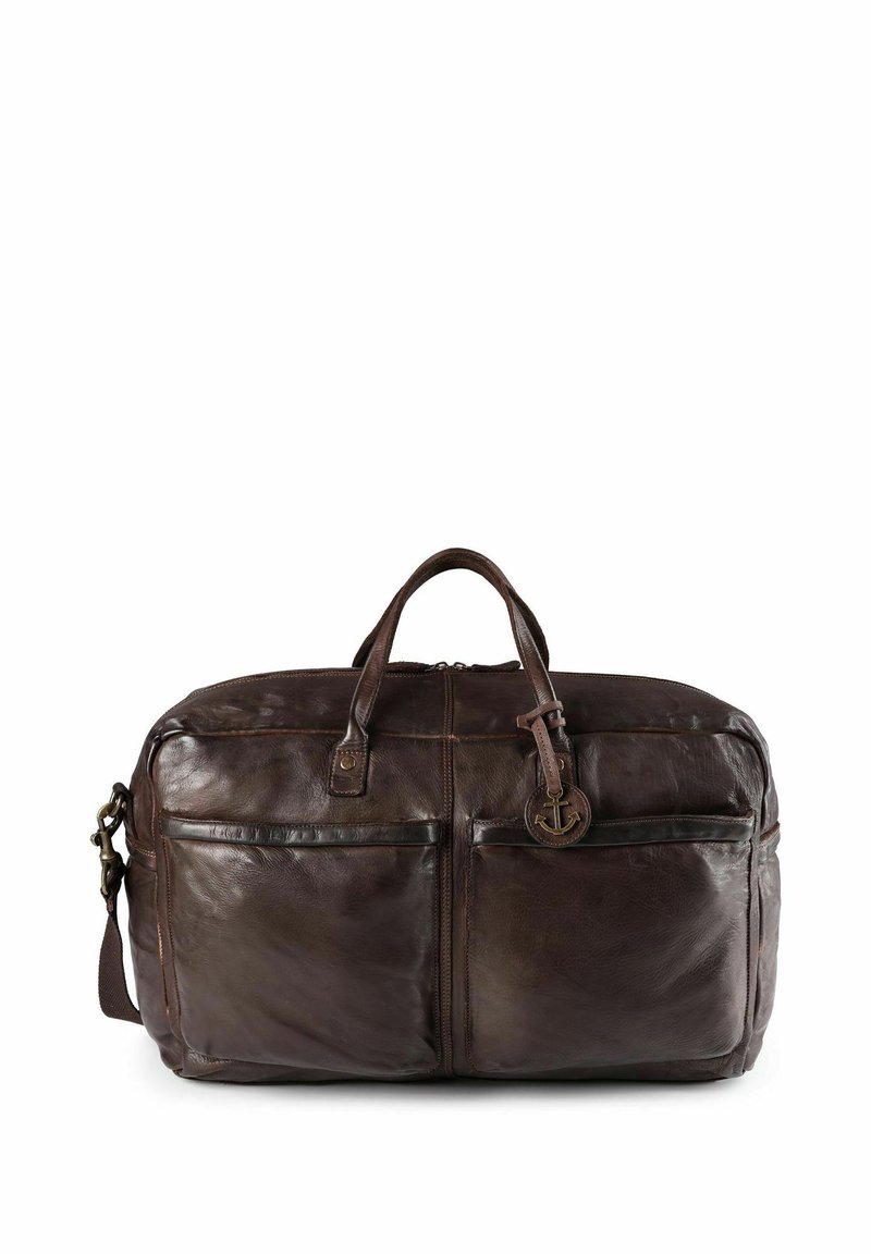 Sac de voyage en cuir marron avec deux poignées et une bandoulière réglable. Il dispose de deux poches avant et d'un pendentif décoratif en forme d'ancre.