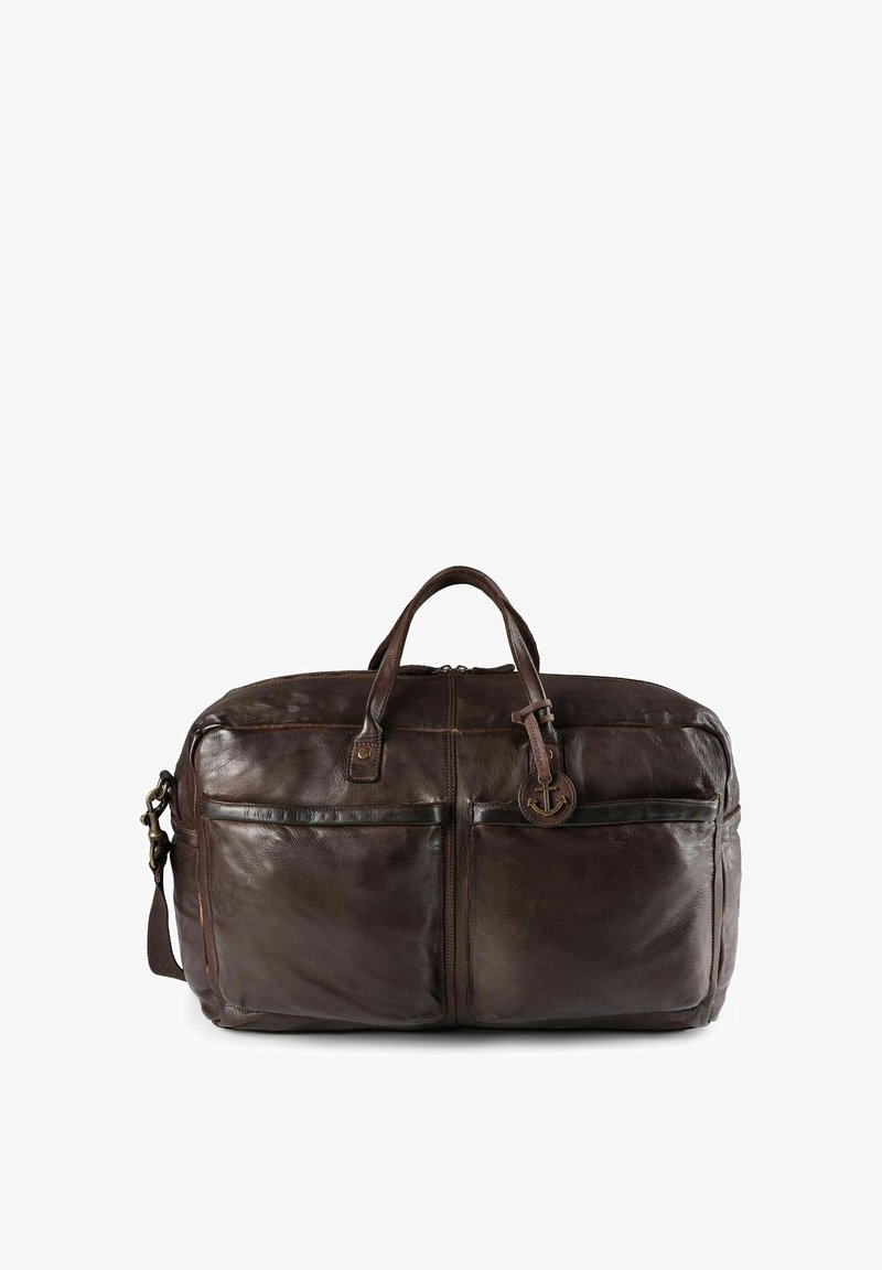 Sac de voyage en cuir marron avec deux poignées et une bandoulière réglable. Il dispose de deux poches avant et d'un pendentif décoratif en forme d'ancre.