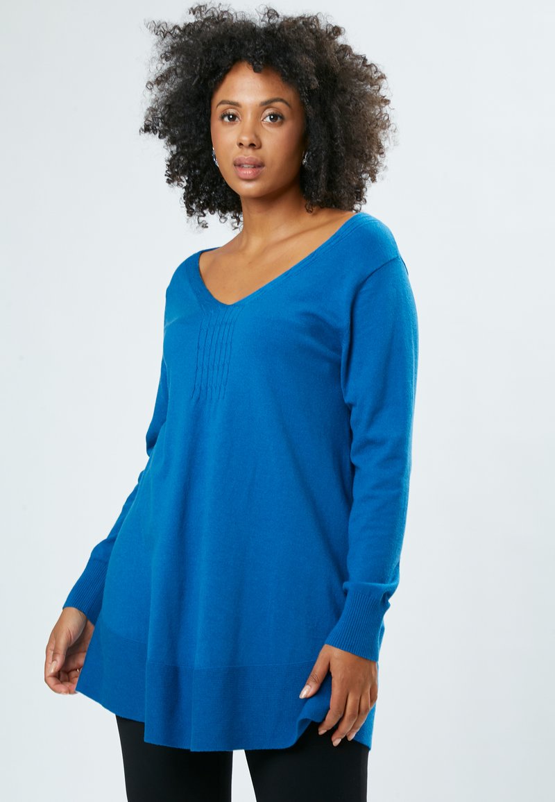 Langärmliger V-Ausschnitt-Pullover in kräftigem Blau mit gerippten Bündchen und subtiler vertikaler Stickerei auf der Brust; weicher, strukturierten Strick.