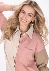 Cămașă din corduroy cu un design în blocuri de culoare roz, bej și cappuccino. Prezintă închidere cu nasturi, buzunare și textură ribbed.