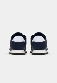 Scarpe sportive marine con accenti bianchi e dettagli rossi. Materiale sintetico liscio, punta arrotondata e suola testurizzata per la trazione.