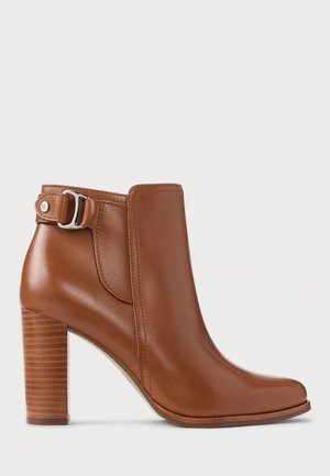 Stivaletto in pelle marrone con tacco a blocco impilato, punta arrotondata e dettaglio in metallo argentato sul retro.
