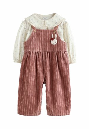 Blusa crema a maniche lunghe con piccolo motivo floreale e grande colletto abbinata a salopette rosa polvere strutturate con toppa a forma di faccia di coniglio.