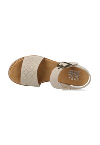 Sandalia beige sin hebillas con tiras de cuero perforado, hebilla ajustable y plantilla texturizada marrón. Punta redondeada y plana, diseño minimalista.
