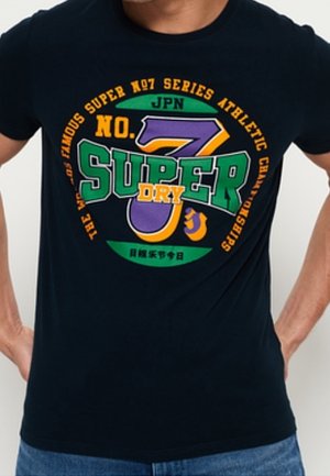 T-shirt bleu foncé avec texte graphique coloré "No. 7 Super Dry" et un grand numéro 7 violet et vert au centre.