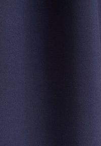 Tissu bleu marine foncé avec une texture fine et tissée serrée, présentant des plis légers créant des ombres et des reflets subtils.