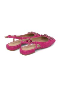 Ballerine in suede rosa con punta affusolata, caratterizzate da strass decorativi sulla parte anteriore e suola piatta. Cinturino regolabile alla caviglia.