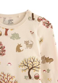 Långärmad babybodysuit i krämfärg med ett mönster av djur och träd i jordnära färger. Utmärkande detaljer inkluderar tryckknappar på axeln.