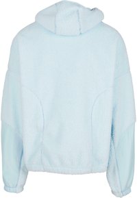 Világoskék kapucnis pulóver puha, bolyhos fleece anyagból. Kényelmes szabással rendelkezik, rugalmas mandzsettákkal és ívelt hátú hemvonalával.
