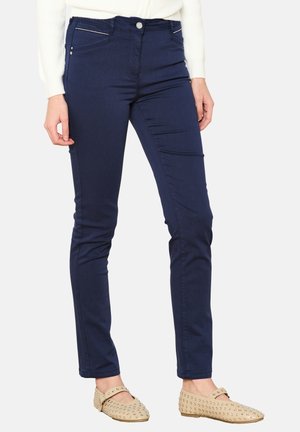 Donkerblauwe stretch jeans met een slim fit, voorzien van voorzakken met rits en zilverkleurige accenten. Soepele stof met een lichte glans.