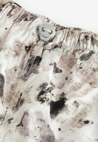 Texturiertes leichtes Gewebe mit einem grau-weißen Grundton, das ein aquarellartiges abstraktes Muster in gedämpften Rosa- und Schwarztönen zeigt, mit elastischem Taillenbund.