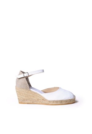 Espadrille blanche à talon compensé avec bride à la cheville, talon en jute tressée et design à bout fermé.
