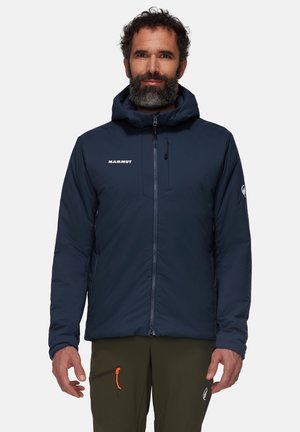 Marinblå isolerad jacka med huva, dragkedjestängning fram och logodetalj. Har fickor med dragkedja och kontrasterande oranga accenter.
