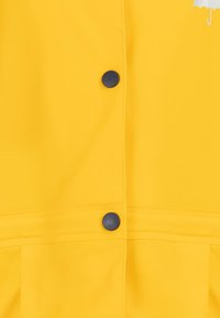 Geltonas vandeniui atsparus švarkas su priekiniais užsegimais mėlynomis sagomis ir subtilia sidabrine skėčio logo ant krūtinės. Sklandus paviršius.