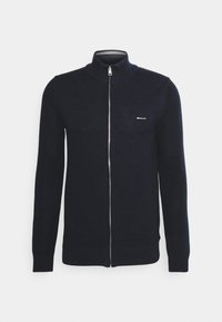 Cardigan zippé tricoté bleu marine avec col montant, motif texturé et logo GANT sur la poitrine. Comprend des poignets et un ourlet ajustés.