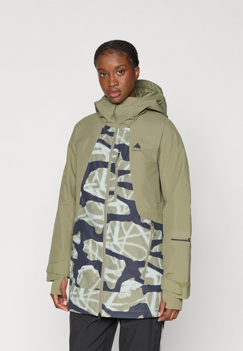 Olive green jacket with geometric camouflage pattern in light blue and navy. Features a zip front, hood, and multiple pockets.