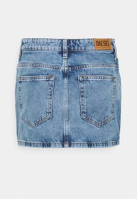 Jeansminikjol i ljusblå tvätt, med två bakfickor och en tan Diesel-logotyp vid midjan. Klassisk femficksdesign.