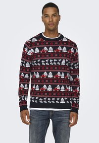 Maglione lavorato a maglia rosso, bianco e nero con un design geometrico che presenta alberi e camion. Collo rotondo e polsini e orlo a coste.