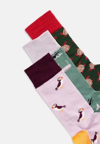 Vier Paare von Socken mit verschiedenen Farben und Mustern: rot, lavendelfarben mit Puffins, grün mit Schildkröten und einem gelben Akzent.