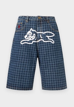 Pantalones cortos de mezclilla con un patrón de pata de gallo oscuro, un diseño de conejo de dibujos animados delineado en blanco en el frente y una pequeña flor roja en el bolsillo derecho.