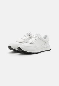 Weiße Ledersneaker mit strukturierten Oberflächen, runder Zehenpartie und grauen Akzenten. Sie verfügen über Schnürsenkel, einen gepolsterten Kragen und eine schwarze Gummisohle.