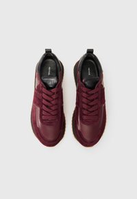 Chaussures de sport bordeaux en cuir lisse avec des panneaux en daim texturé, à bout rond, au design à lacets et à semelle en caoutchouc.