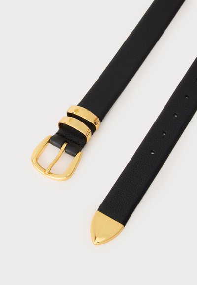 Ceinture en cuir noir avec boucle dorée, deux passants dorés et une extrémité dorée posée à plat sur un fond clair.