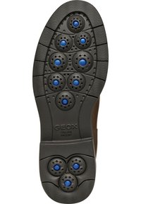 Suela de zapato de goma negra con doce agujeros de ventilación en forma circular de color azul, superficie texturizada con ranuras y marca Geox.