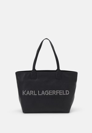 Czarna torba typu tote z dwoma uchwytami i napisem „KARL LAGERFELD” wykonanym z małych srebrnych ćwieków na przedzie.