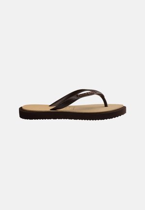 Enkelt beige og mørkebrunt flip-flop sandaler med teksturert såle og enkel stropp mot ensfarget bakgrunn.