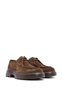 Chaussures en suède marron avec une forme arrondie, des coutures contrastées et de grosses semelles en caoutchouc dotées d'un motif de semelle pour une meilleure adhérence.