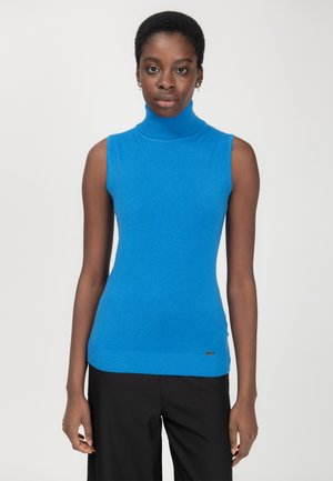 Top sans manches bleu à col roulé en tricot doux, avec un ourlet côtelé et un discret logo en bas.