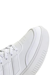 Baskets blanches avec une tige synthétique texturée, bout rond, design à lacets et semelle épaisse et crantée. Présente des accents cousus et des trous de ventilation.