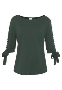 Dunkelgrüne Bluse mit Dreiviertelärmeln, Schleifenbindungen an den Bündchen und Perlenakzenten entlang der Ärmel. Glattes, leichtes Material.