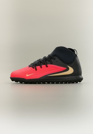 Μαύρο και κόκκινο αθλητικό παπούτσι Nike με μέτριο ύψος, μπεζ λογότυπο Swoosh και μαύρα κορδόνια, σχεδιασμένο για παιχνίδι σε πλαστικό χλοοτάπητα ή εσωτερικούς χώρους.