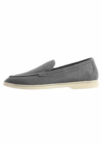 Grijze suède loafers met een slank profiel, een ronde neus en een beige rubberen zool. Beschikt over een gestikt randje en een instapontwerp.
