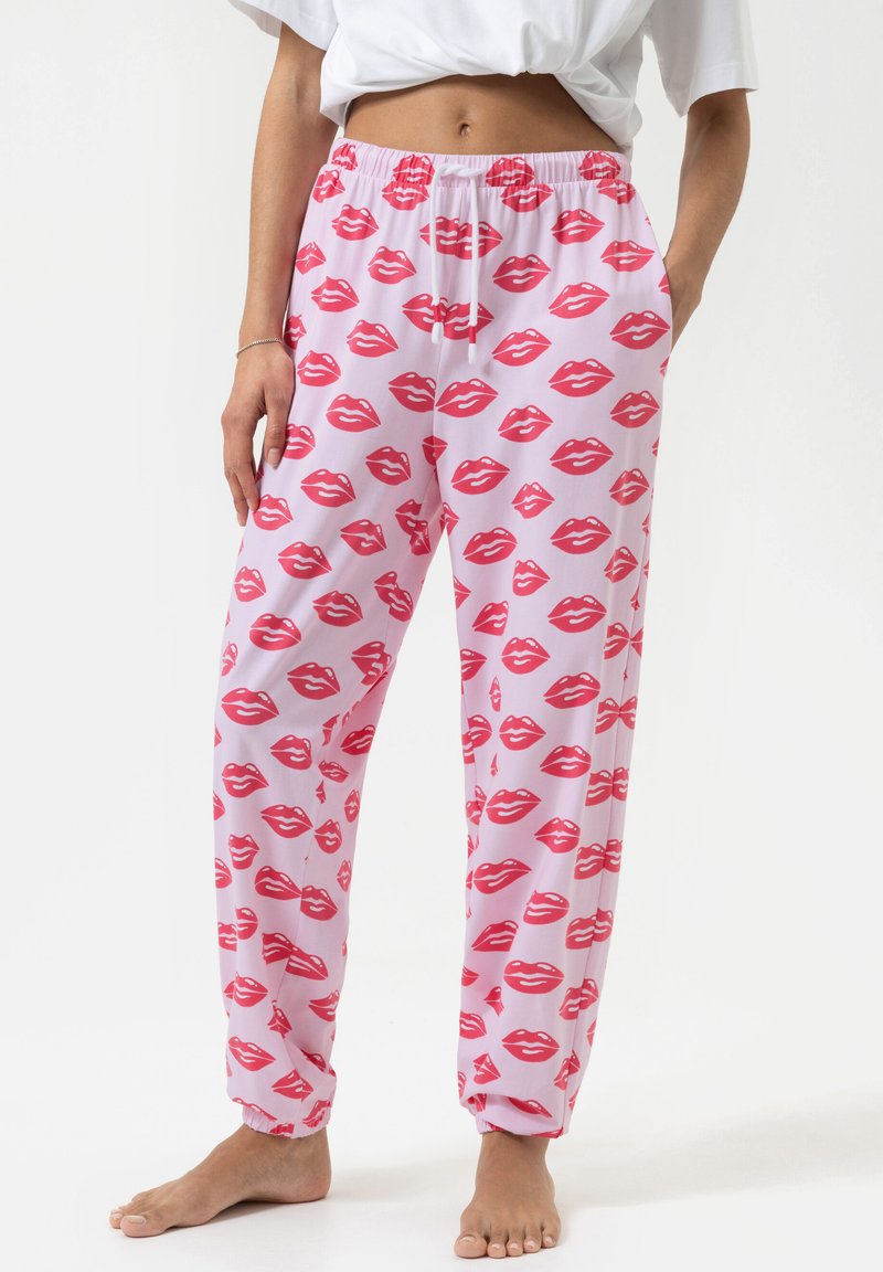 Roze pyjamabroek met een herhaald patroon van rode lippen. Gemaakt van een zachte stof met een elastische tailleband en manchetten.
