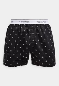 Μαύρα μποξέρ Calvin Klein με λευκή ελαστική μέση και μικρά λευκά λογότυπα "cK" τυπωμένα παντού.