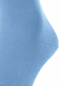 Calzino di cotone azzurro chiaro, caratterizzato da una fine trama a coste e una forma affusolata con un design della punta senza cuciture. Materiale liscio e elastico.