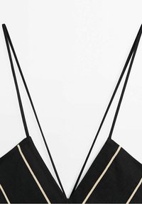 Haut en lin noir avec un décolleté en V profond, doté de fines bretelles réglables et de rayures horizontales crème. Texture lisse avec un design minimaliste.