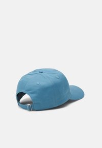 Blå bomullslue med buet skygge, justerbar stropp bak, seks paneldesign og ventilasjonshull for pusteevne.