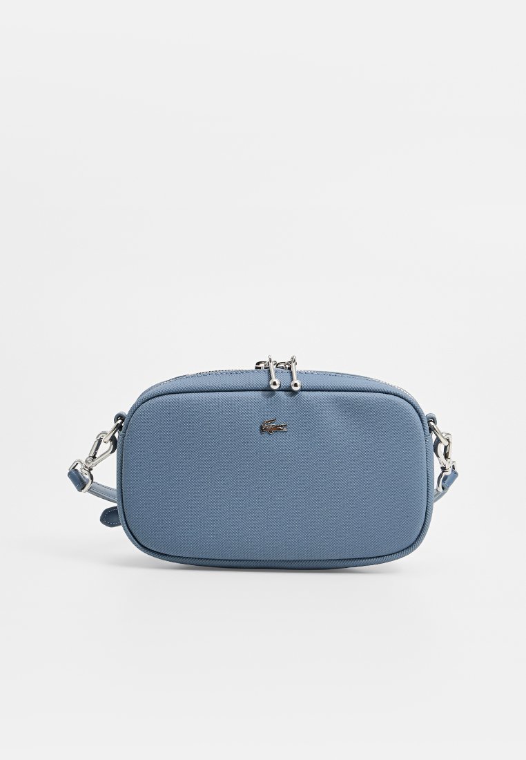 Sac bandoulière synthétique bleu de forme rectangulaire, surface texturée, éléments en métal argenté et détail de logo sur le devant.