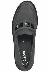 Mocasines de ante gris con suela plana y tachuelas piramidales negras decorativas en la correa. Forro interior suave con el logo de la marca.