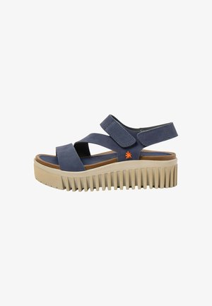 Sandalia azul marino con dos correas ajustables, logo de estrella naranja, plantilla marrón y suela de plataforma beige gruesa y acanalada.