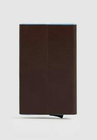 Cuaderno de cuero marrón con textura suave, forma rectangular, bordes azules y cierre con banda elástica negra.