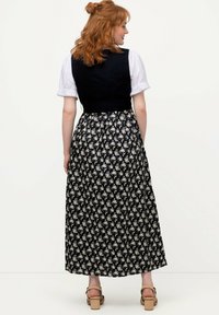 Vestido floral azul y blanco con un corsé negro ceñido y una falda fluida. El material es ligero con una textura suave y mangas cortas abullonadas.