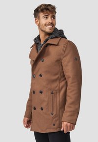 Hnědý vlněný kabát s dvojitým zapínáním, černými knoflíky, bočními kapsami a šedou vzorovanou kapucí viditelnou pod ním.